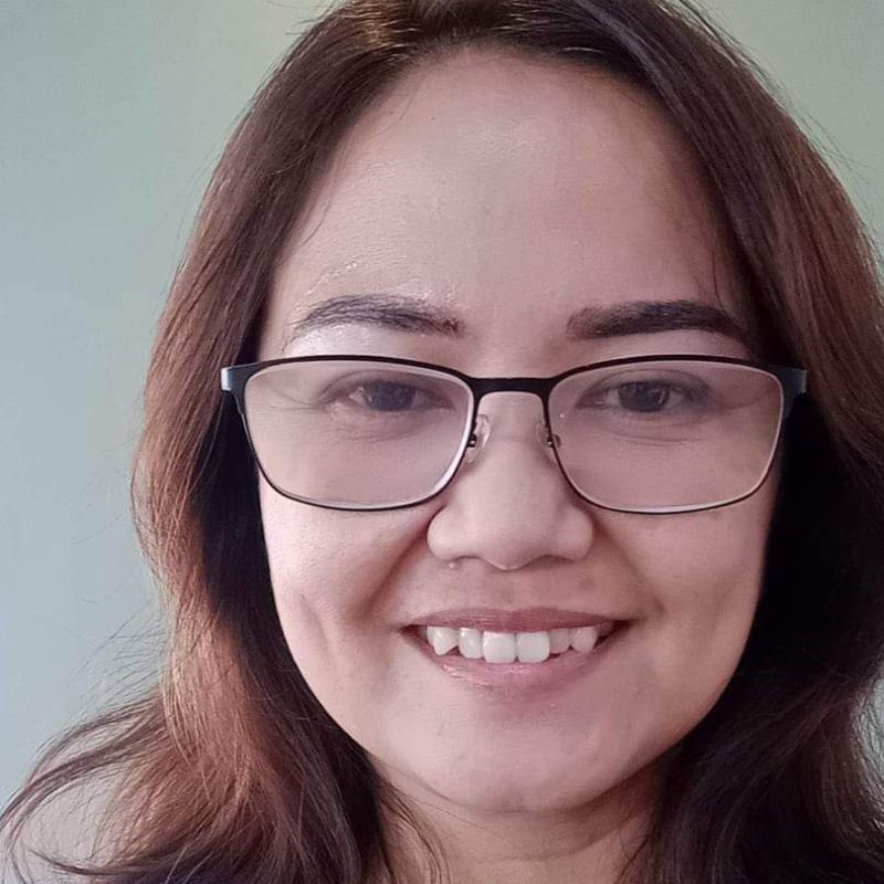 Headshot of asian women smiling and wearing glasses.