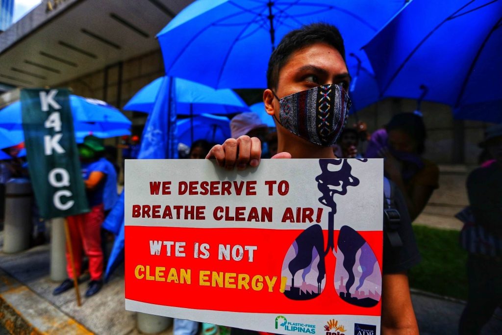 Climate activist holding a placard calling for his right to clean air and waste-to-energy (WtE) incineration is not clean energy