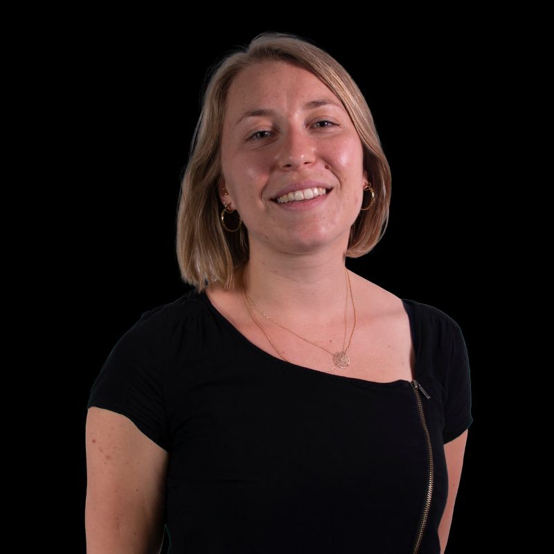 Headshot of woman on black background.