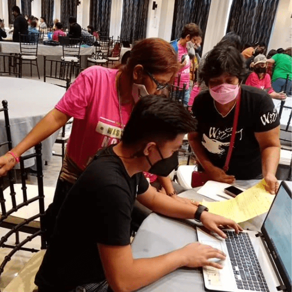 a group of people huddled around in a discussion