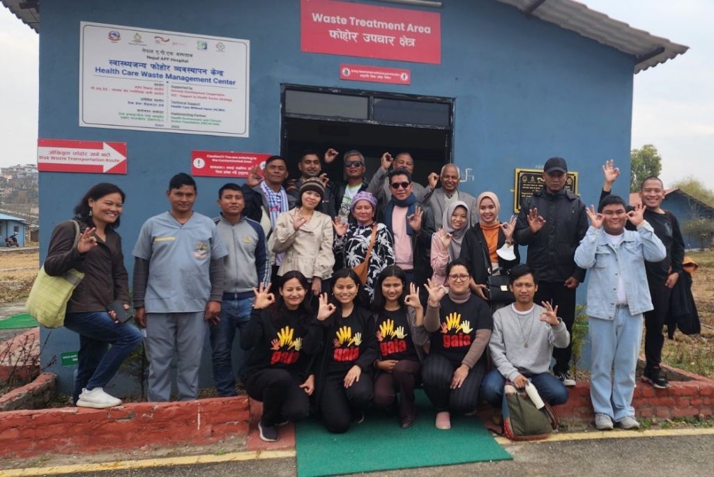 a group pf people standing in front of a waste management facility.