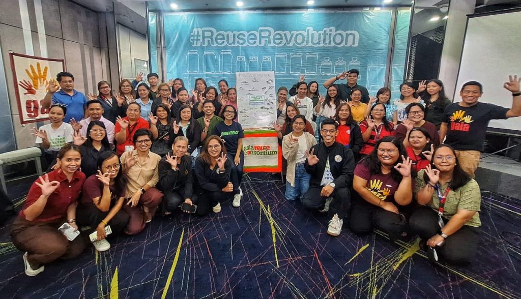 group of people in front of a banner that says "Reuse Revolution"