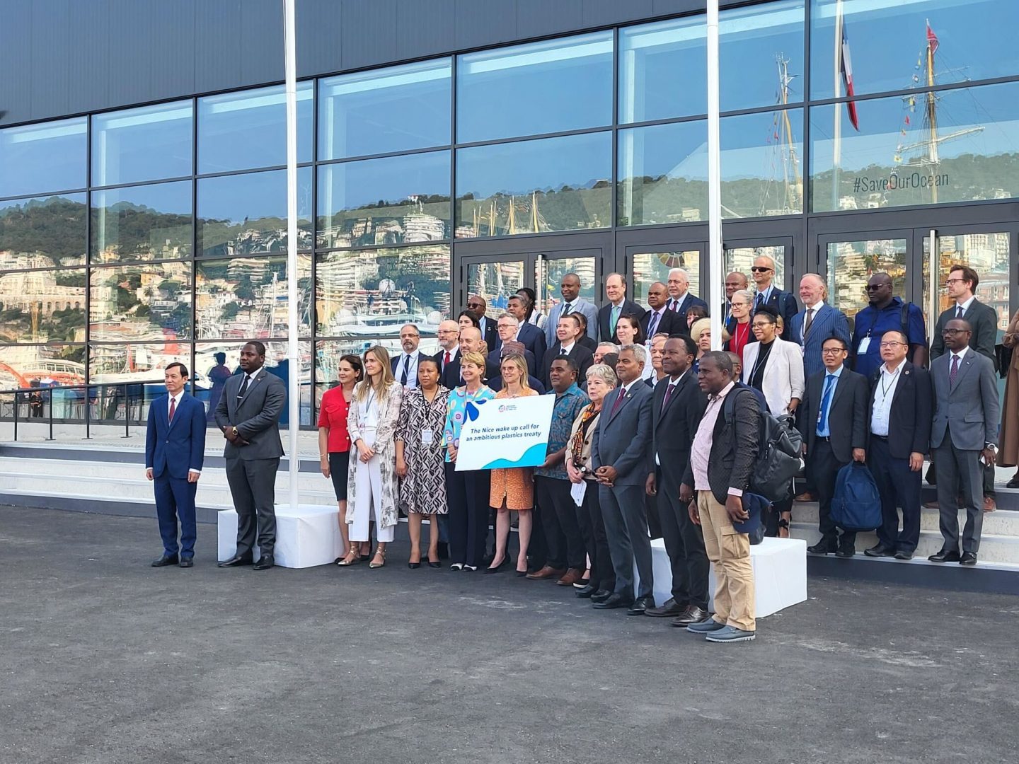 People posing for a photo in front of a glass building