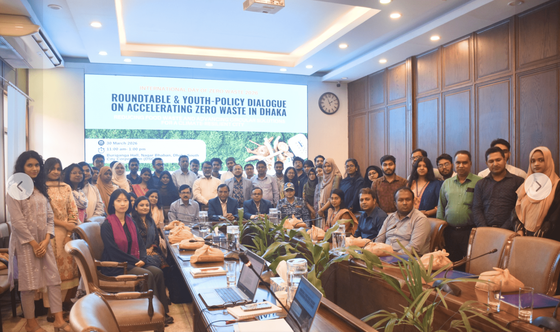 a group of people by a powerpoint reading roundtable youth policy for acceleration of zero waste in Dhaka